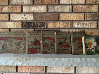 Seven books on brick mantle including five Burgess titles and one pictorial board book