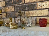 Group view of brass and glass items on mantle