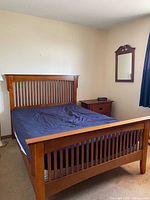 Full view of bed frame with headboard, footboard, mattress, bedside table visible