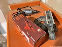 Overview of drill, boxed router edge guide, metal plate and bracket