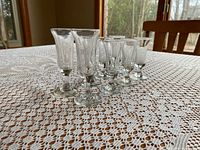Eight clear cordial glasses on lace tablecloth