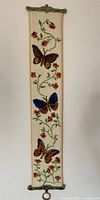 Full view of vertical needlepoint tapestry with three butterflies and floral design