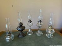 All five oil lamps lined up showing relative sizes and shapes