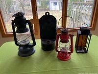 Group view of four lanterns and candle holders on table