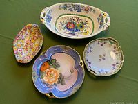 Top view of four antique English serving dishes showing patterns, shapes and condition