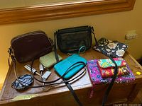 All seven bags and wallets arranged on wooden surface