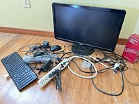 Lot overview showing Dell monitor, keyboard, mouse, power strip, cables and cleaning wipes