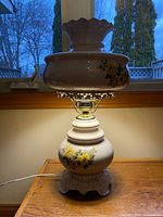Full view of lit ceramic floral oil lamp converted to electric