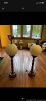 Pair of matching globe lamps on floor showing full height and design details