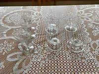 Seven pieces of clear crystal stemware arranged on lace tablecloth