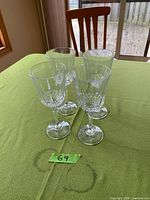 Four matching crystal wine glasses on green cloth