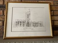 Front view of framed black-and-white sketch print showing artwork, mat, and gold frame