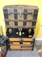 Front view of three stacked steamer trunks showing colors, hardware, panels