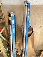 Close-up of two blue Da-Lite projector screen housings and support rods