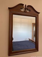 Front view of rectangular mirror showing wood frame and pediment