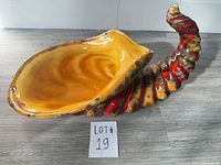 Side view of ceramic cornucopia vase showing full horn shape and glaze