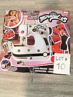 Front of sealed Miraculous sewing machine box showing product image and logo