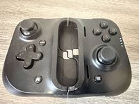 Front view showing buttons, analog sticks, and empty center section with Lightning connector