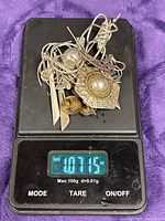 Mixed sterling silver jewelry pile on scale reading 1.071 oz