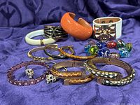 All 12 bracelets displayed on purple fabric