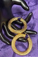 Front view of both ribbed gold plated hoop earrings