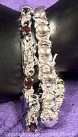 Both bracelets on display, showing link styles and garnet stones