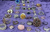 All rings laid out on purple fabric, wide view