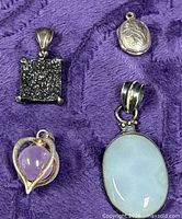 Group shot of four pendants on purple fabric
