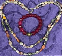 Necklace and bracelet coiled on fabric showing bead colours and clasp