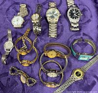 Group shot of all wristwatches on purple fabric background