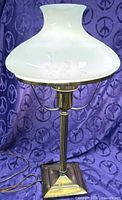 Full view of lamp showing brass base, column, support arms, curved glass shade
