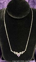 Full necklace on black display showing chain and central stone setting