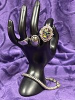 All four jewellery pieces displayed on mannequin hand