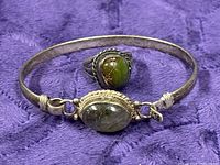 Moonstone bangle and turquoise ring together on fabric background