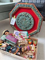 Lot overview showing wall plaque and box of souvenirs