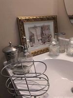 Overall view of vanity pieces and framed print on sink