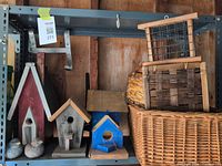 Overview of birdhouses, concrete birds, suet feeder and baskets on shelf
