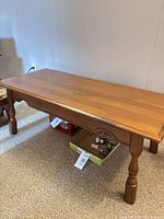 Full view of rectangular wood coffee table on carpeted floor