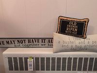 Throw pillows and wooden plaque displayed together