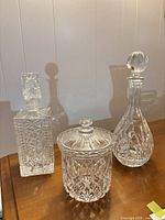 Square whiskey decanter, lidded ice bucket, teardrop wine decanter on table