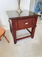 Front angled view showing drawer, legs, stretcher base