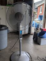 Full view of Sylvania pedestal fan showing base, pole, grille, and power cord