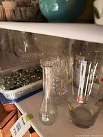 Shelf with three vases and container of glass stones