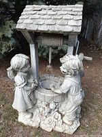 Front view of resin statue showing boy and girl at well