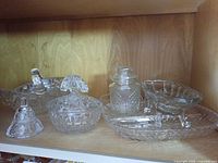 All six pressed glass pieces on shelf