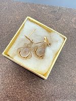 Earrings in box showing overall design, filigree detail and stones