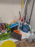 Shelf with broom, cleaners, sliders box, bucket, green bin of small items