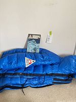 Blue down coat with Everest ’82 patch and accompanying map booklet visible