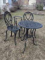overall view of table, two chairs, plant stand