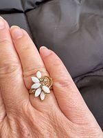 Ring on hand showing marquise opal stones and accent stones